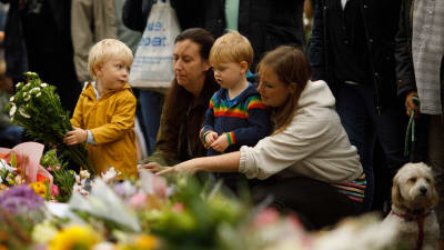 Barn och vuxna lämnar blommor utanför Windsor Castle för att hedra minnet av drottning Elizabeth II.