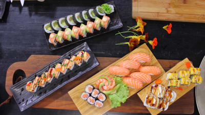Olika portioner av sushi på ett bord i ett kök