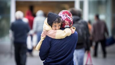 En asylsökande bär på sitt barn.