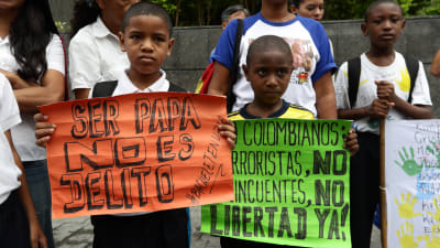 Två barn deltar i en demonstration för mänskliga rättigheter utanför ett FN-kontor i Caracas