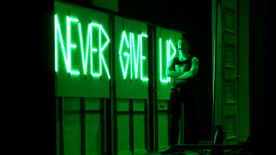 Orden "Never Give Up" i neonskrift i Svenska teaterns uppsättning av "Titanic".