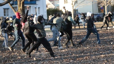 Demonstranter som kastar sten mot polisen i Örebro.