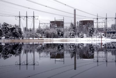 Ett vintrigt landskap med två kärnreaktorer och elledningar