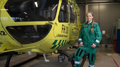 Ensihoitolääkäri Susanne Ångerman seisoo helikopterin vieressä Vantaan FinnHEMS-tukikohdassa.