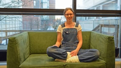 Elin Gustafsson sitter i en grön soffa.