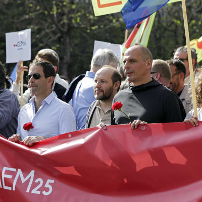 Greklands tidigare finansminister Yanis Varoufakis håller en Diem 25-banderoll under en demonstration i Portugal.