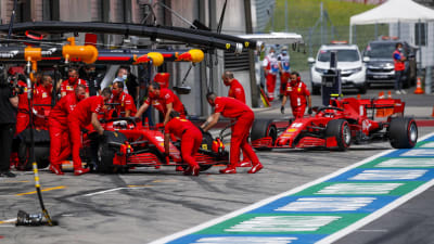 Mekaniker rullar in Ferraribilarna i garaget. 