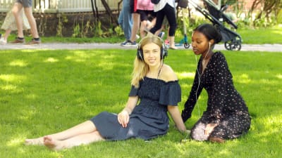 Två unga kvinnor lyssnar på ljuddramat Röster från pestens år.