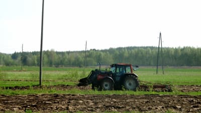 Traktor på åker.
