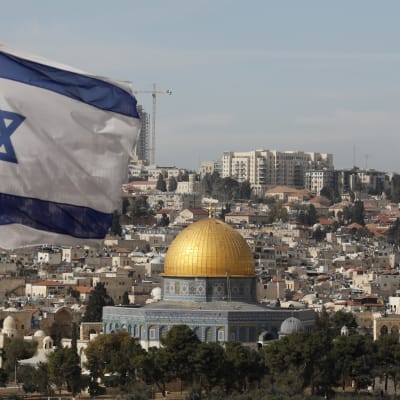 En vy över Jerusalem med Israels flagg i förgrunden. 