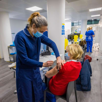 En kvinna vaccineras mot covid-19 i England.