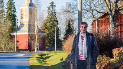 Anita Wikman framför Munsala kyrkas klockstapel