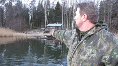 Person står i båt och pekar mot land