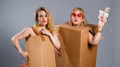 Två kvinnor står klädda i pafflådor och klackskor.