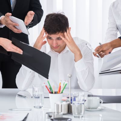 Arbetstagare blir stressad av mängden arbete framför sig.