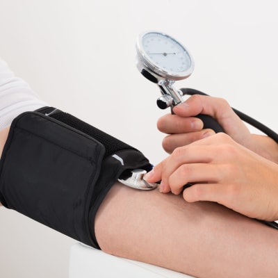 Läkare mäter blodtrycket på en patient.