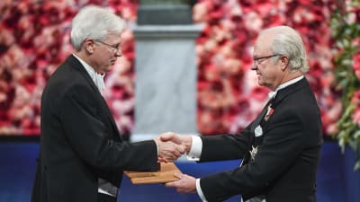 Bengt Holmström tar emot ekonomipriset av kung Carl Gustav.