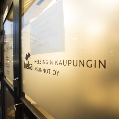 En glasdörr med texten "Helsingin kaupungin asunnot oy" och "heka".