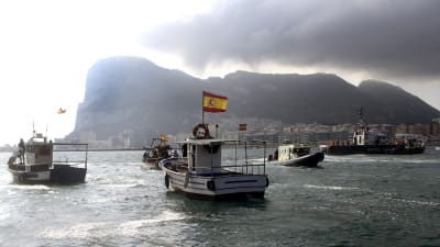Spanska fiskebåtar med flaggor seglar förbi Gibraltarklippan.