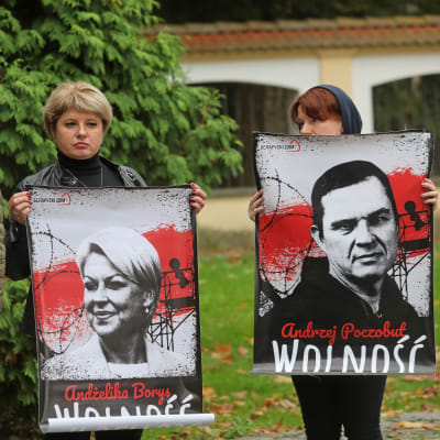 Människor håller upp plakat med bilder på gripna belarusiska journalister.
