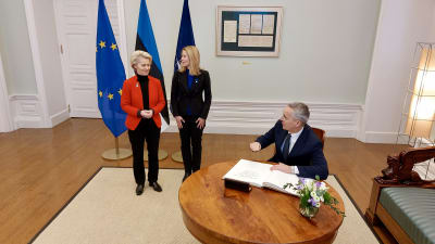 Natos generalsekreterare Jens Stoltenberg sitter vid gästboken medan EU-kommissionens ordförande Ursula von der Leyen och Estlands premiärminister Kaja Kallas står bakom. 