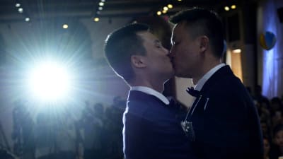 Sun Wenlin och Hu Mingliang kysser varandra under deras bröllopsceremoni i Kina.