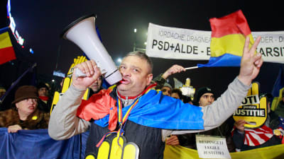 En man ropar slagord i en megafon under demonstrationen utanför regeringspalatset i Bukarest, 26.11.2017.