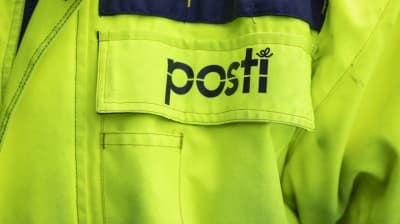 Postin logo postinjakajan takissa. 