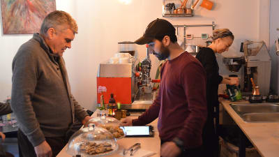 Wisam Abud betjänar en kund på Cafe Damascus.