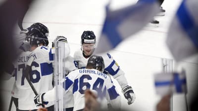 Finlänska ishockeyspelare i ett hav av flaggor.