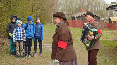 Två röda musikanter (Satu Wendell och Olli Liljeström) försöker få skolbarnen med i sången.
