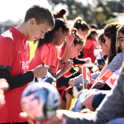Kanadensiska spelare skriver autografer.