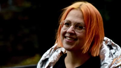 Bild på kvinna i silvrig jacka som ler mot kameran. Personen är Catariina Salo.
