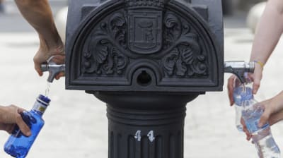 Vattenflaskor fylls vid en pump.