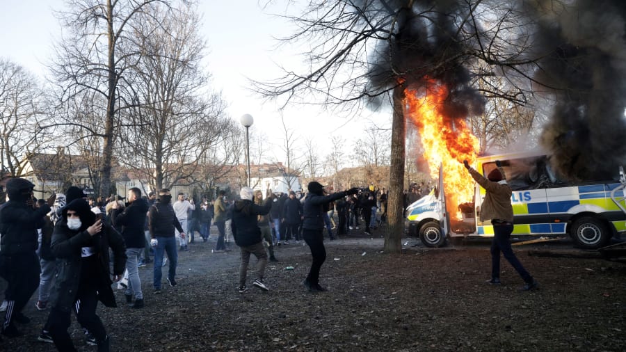 Demonstranten und ein brennendes Polizeiauto in Örebro.