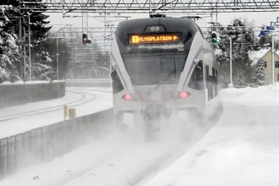 Tåget till flygplatsen i Helsingfors fotograferat i snöyra på Mosabackas tågstation. 