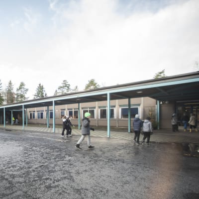 En skolgård med barn som springer runt.