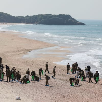 Soldater som arbetar med att rengöra en strand