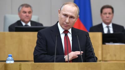 Rysslands president Vladimir Putin står vid ett talarpodium.