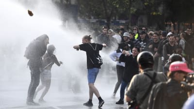 Polisen sprutar vatten på demonstranter. 