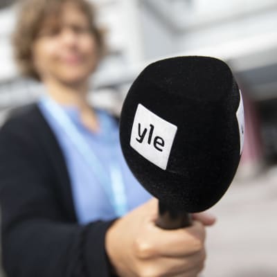 An editor holds an Yle microphone.