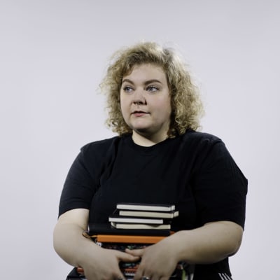 Ida Kronholm med en hög böcker i famnen.
