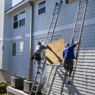 Invånare i North Carolina förbereder sig för orkanen Florence genom att sätta skivor framför husfönstren.