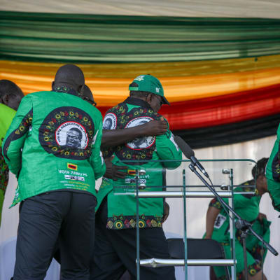 Säkerhetsmän för folk i säkerhet efter en explosion vid ett valmöte i Zimbabwe