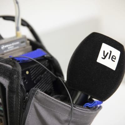 En mikrofon sticker ut ur reporterväskan.