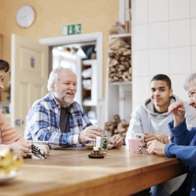fyra personer dricker kaffe vid ett bord