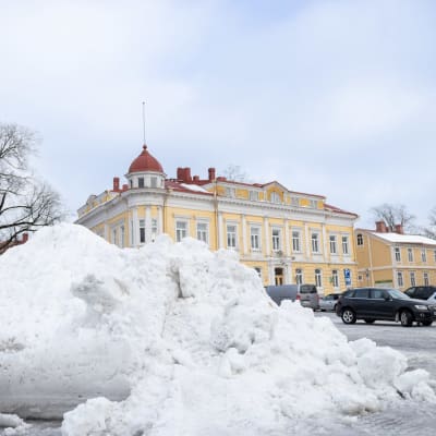 Snöhög i mitten av parkeringsområde. 