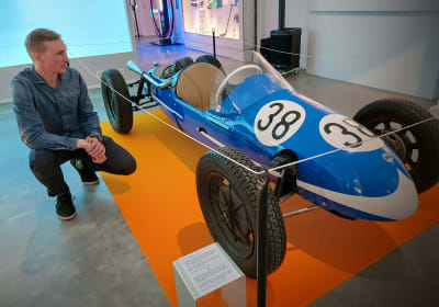 Utställningsanvarige Kalle Rantala på huk (Tahto) invid Curt Lincolns legendariska Midget.