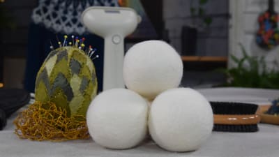 Tre vita tovade bollar av ull på ett bord.