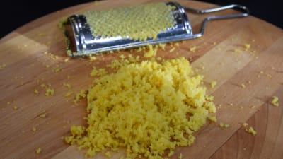 Riven citronskal på en skärbräda